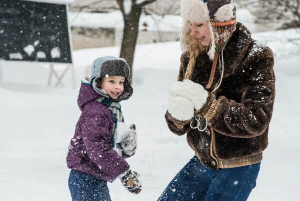 Woman and child play together in the snow to show health attachment as taught by Dr. Mate